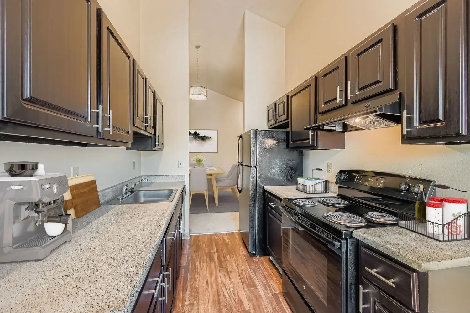 Kitchen with dark cabinets, granite countertops, and black appliances.