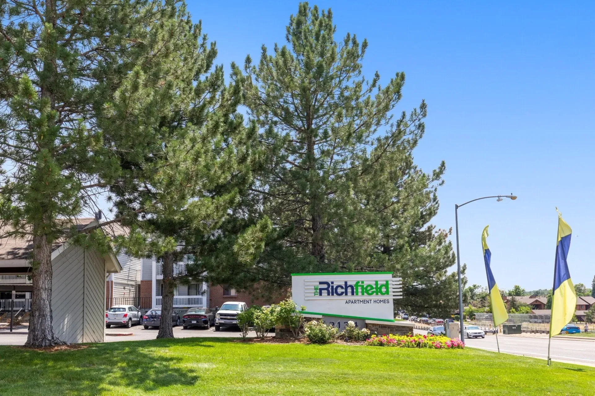 The Richfield Apartment Homes monument sign with trees and blue sky in the background.