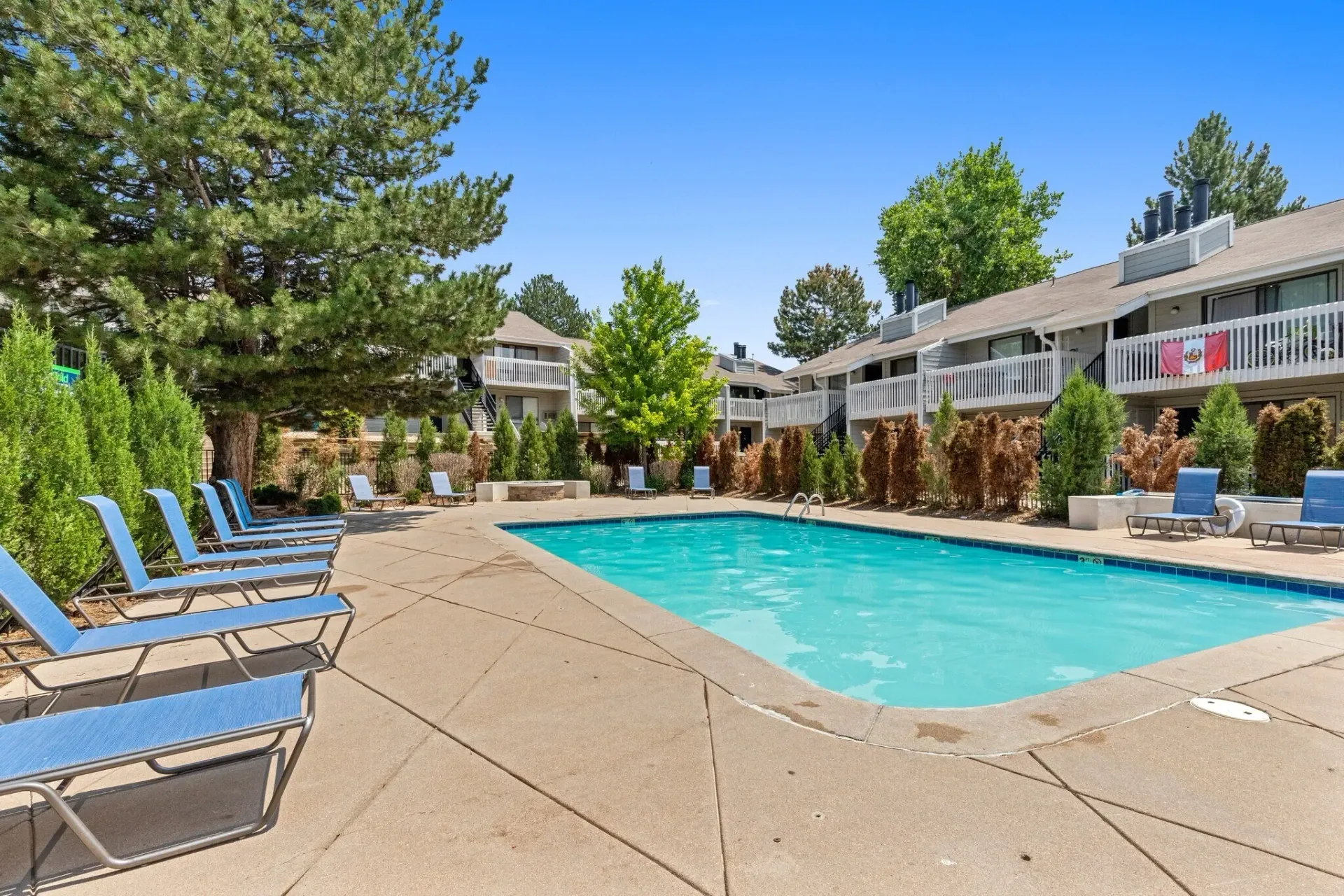 Swimming pool and lounge chairs with apartment buildings in the background