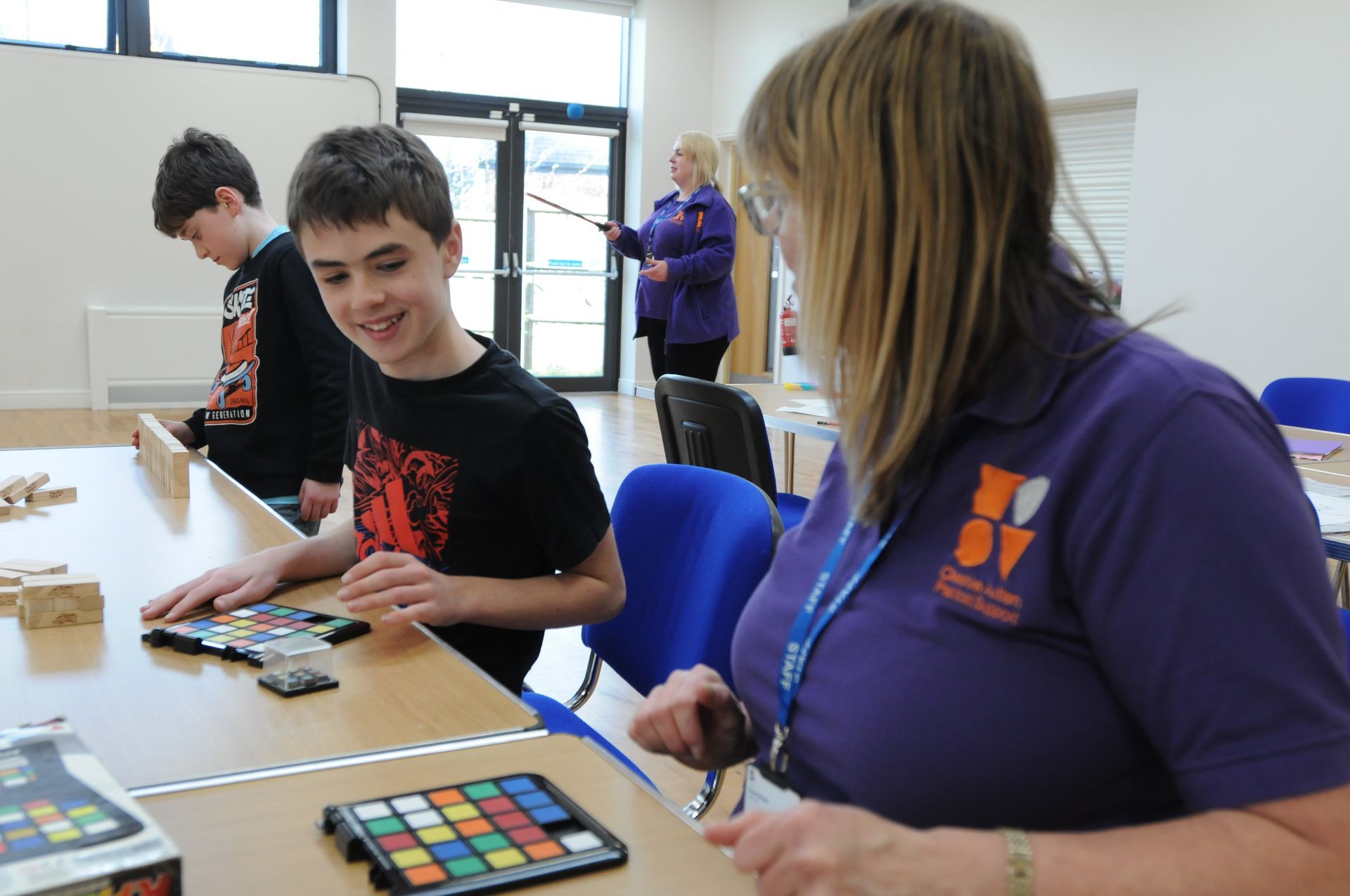 A woman in a purple shirt is playing a game with a boy