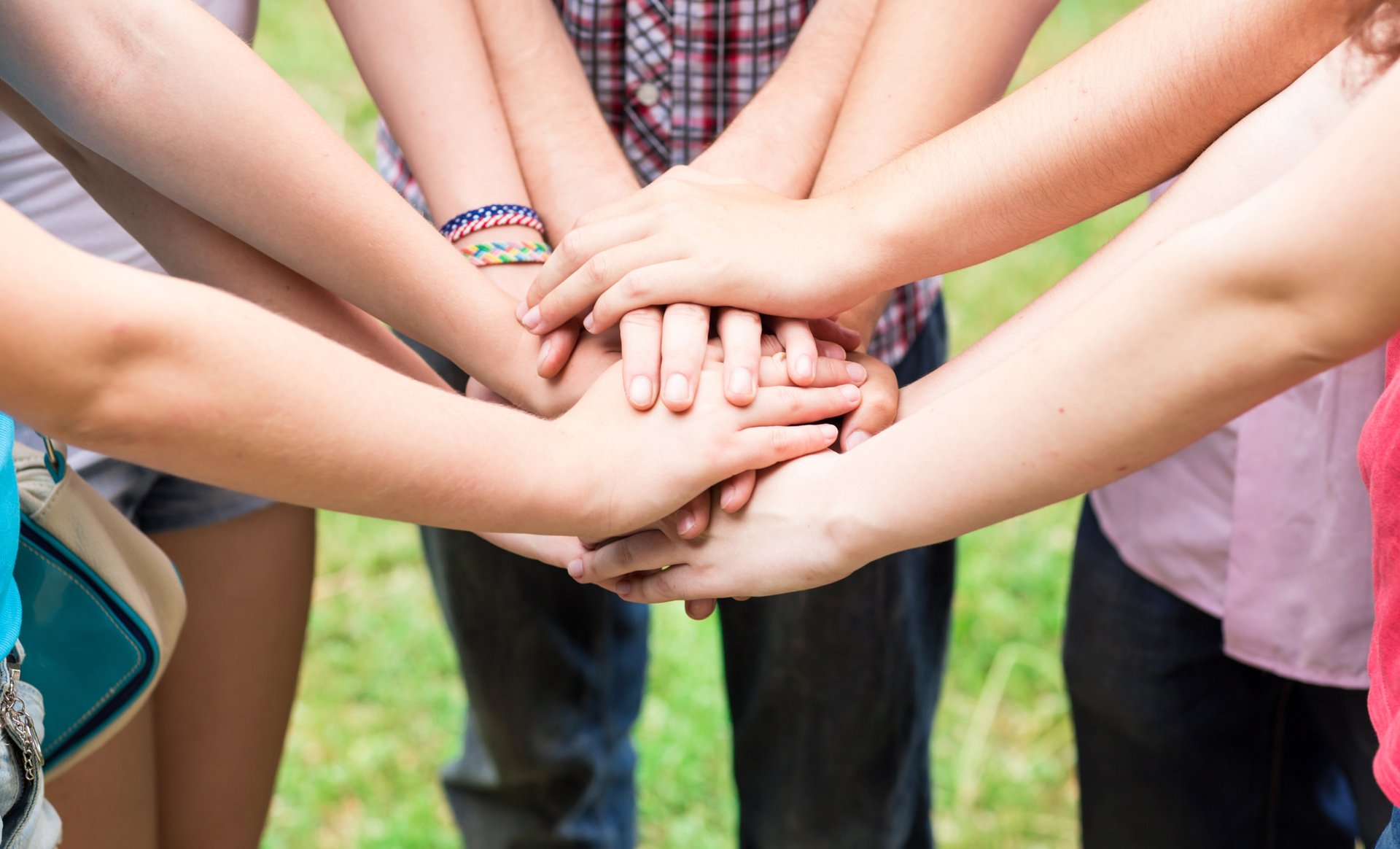 Group of children in a circle with hands joined in the centre