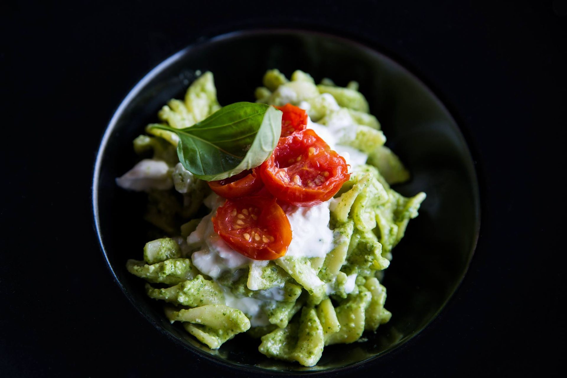 Insalata di frutti di mare gourmet con guarnizione colorata in una ciotola bianca, condita con salsa scura.