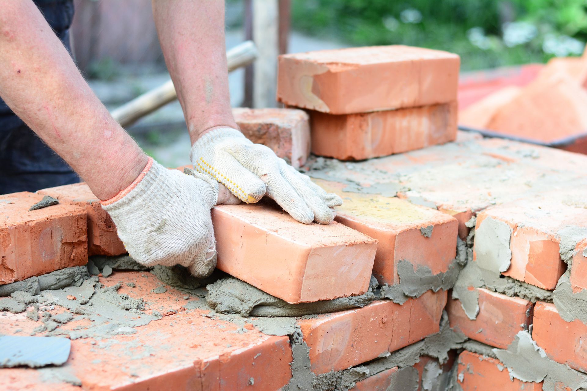 A bricklayer lays bricks as part of a masonry repair job in Wichita, Kansas. 