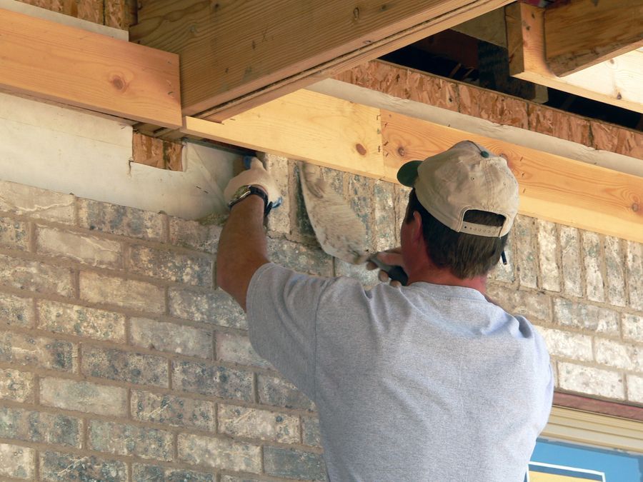 A brick mason with Wichita Masonry installs the final bricks on a new construction job in Wichita, KS.