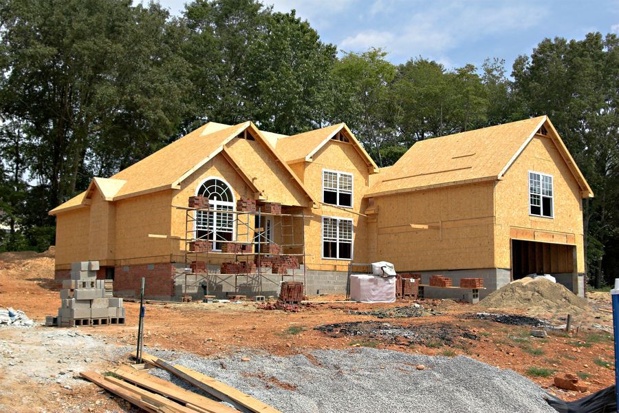 Brick is staged on scaffolding surrounding a new home being constructed in Southwest Wichita in preparation lay brick over a concrete block foundation as well as the walls.  
