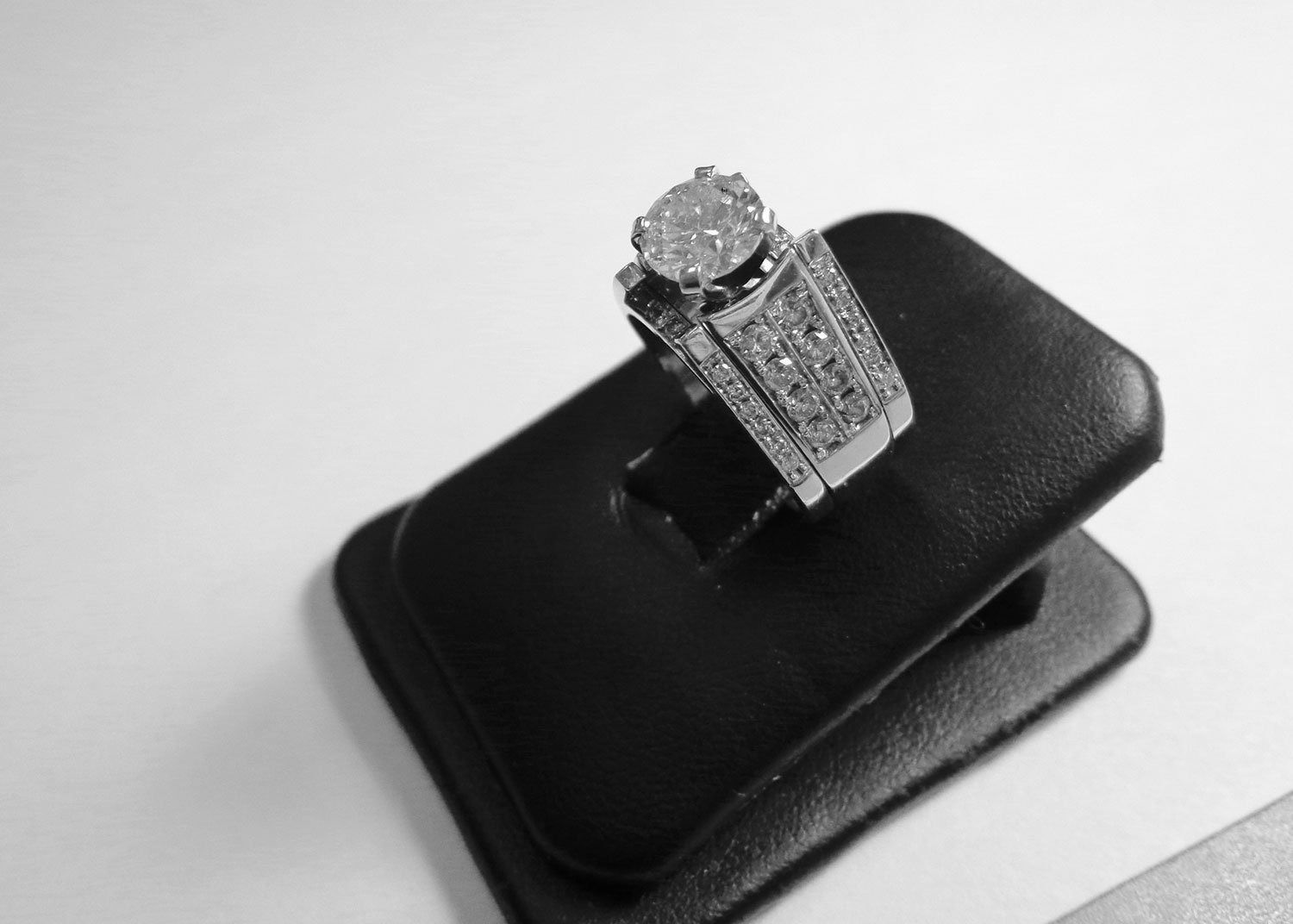 Diamond ring on a black display stand against a light background