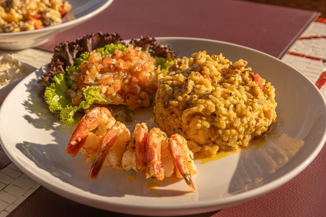 Um prato branco coberto com camarão e arroz sobre uma mesa.
