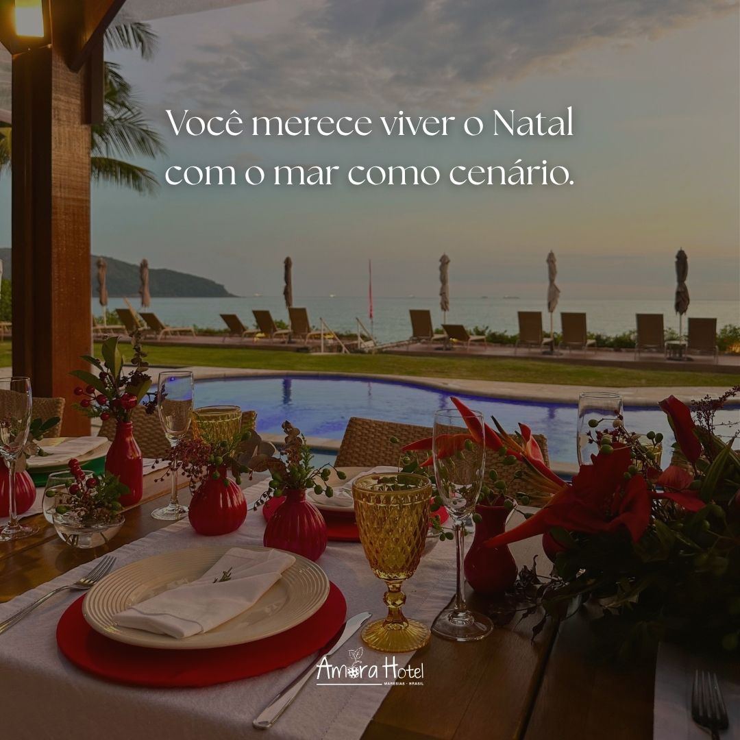 Mesa posta à beira da piscina com vista para o mar ao pôr do sol, com texto promocional sobre o Natal.