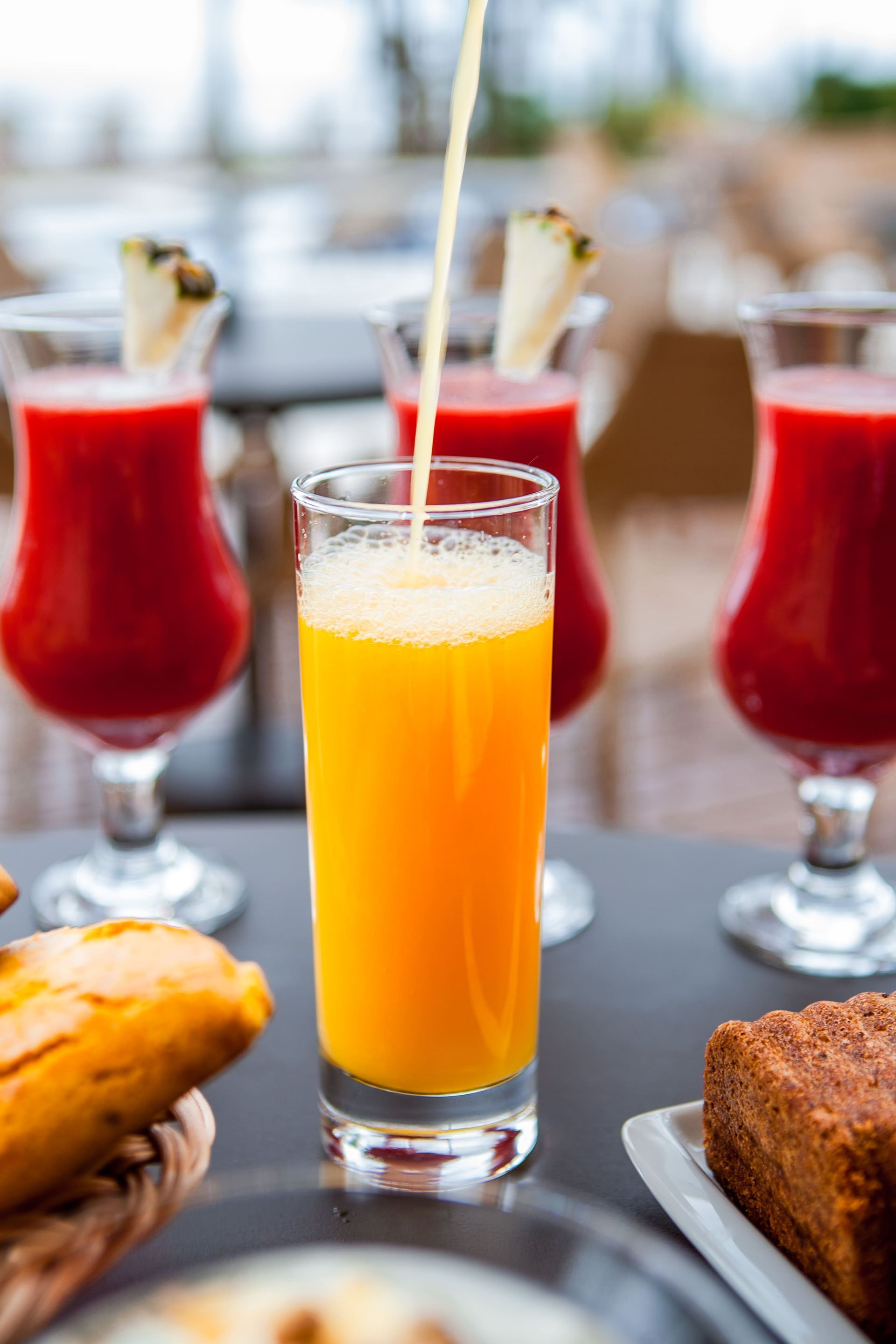 Um copo de suco de laranja está sendo servido em um copo sobre uma mesa.