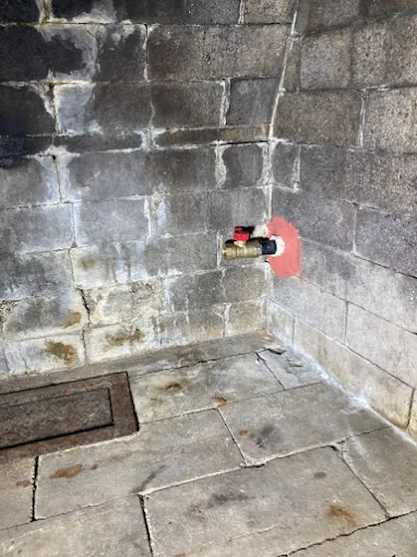 Concrete utility corner with a wall valve and floor drain