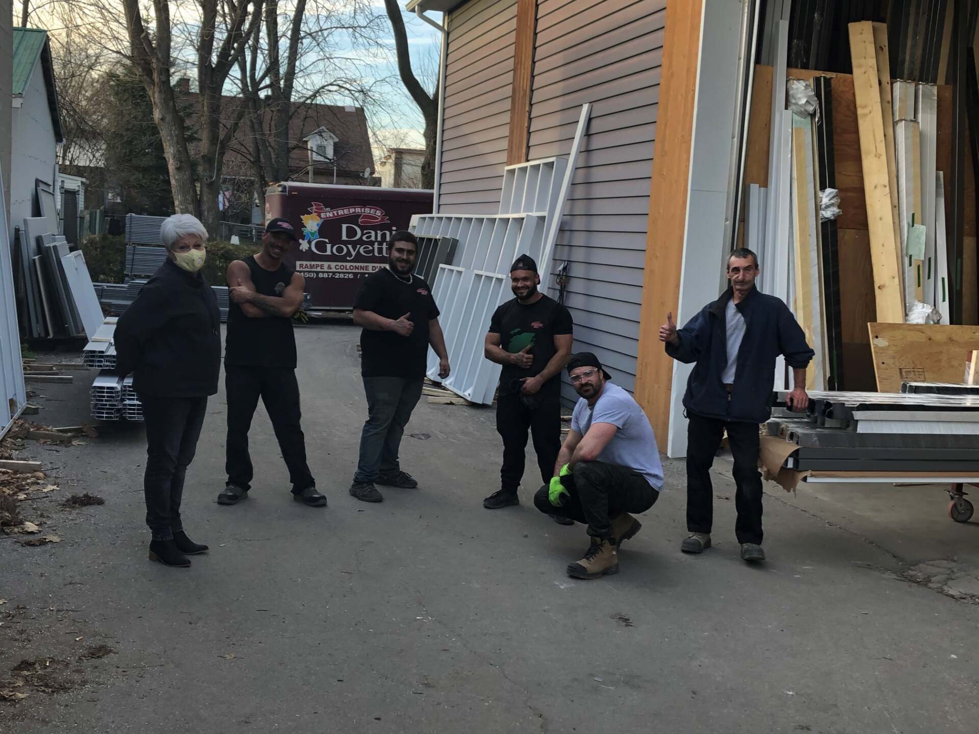 Un groupe d'hommes pose pour une photo devant un immeuble.