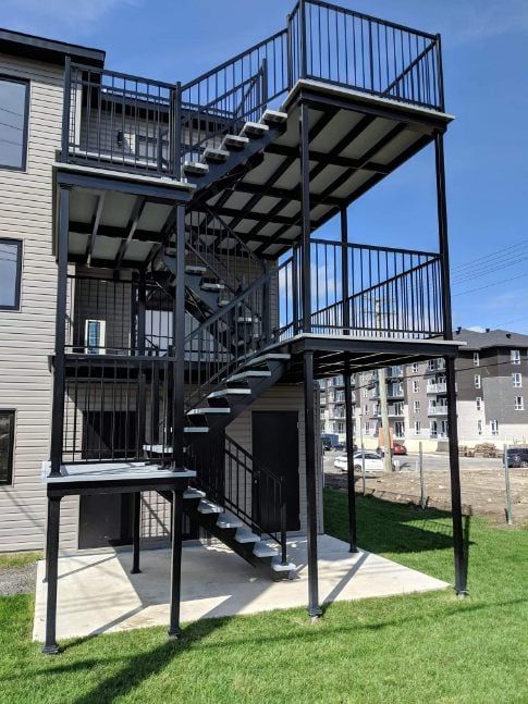 Un bâtiment avec un balcon et des escaliers sur le côté.