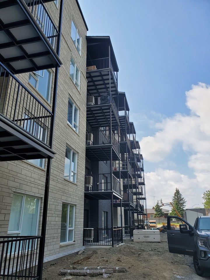 Un grand immeuble d'appartements en construction avec un camion garé devant.