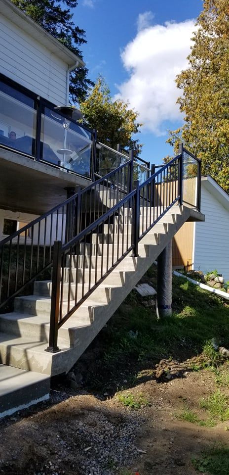 Un ensemble d'escaliers menant à une terrasse avec une balustrade en verre.
