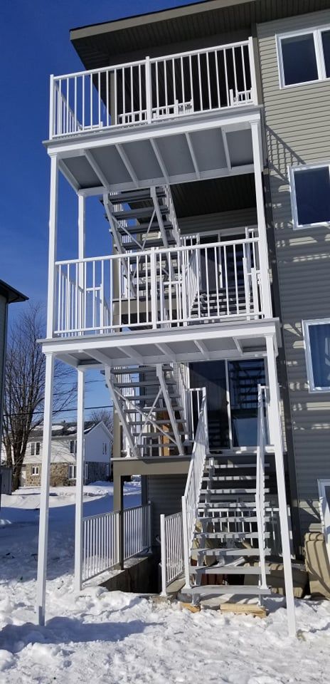Un bâtiment avec un balcon et des escaliers sur le côté.