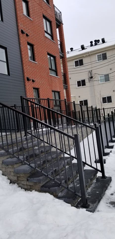 Un escalier menant à un bâtiment avec une balustrade dans la neige.