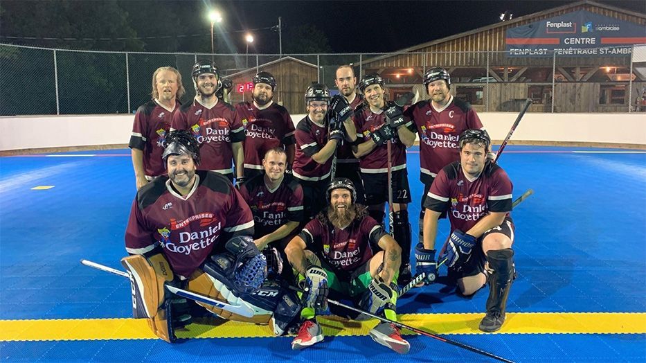 Un groupe de joueurs de hockey pose pour une photo sur une patinoire.