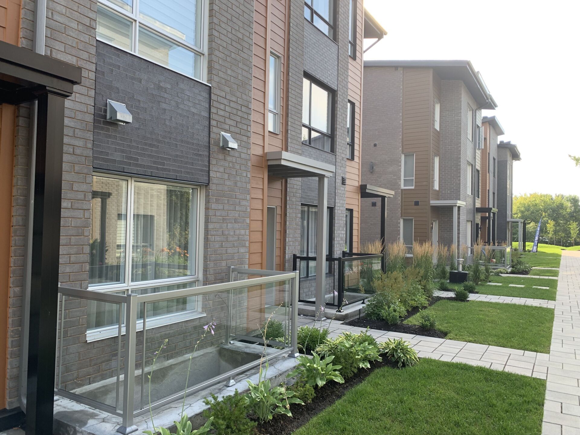 Une rangée d'immeubles d'appartements avec une pelouse verte luxuriante devant eux.