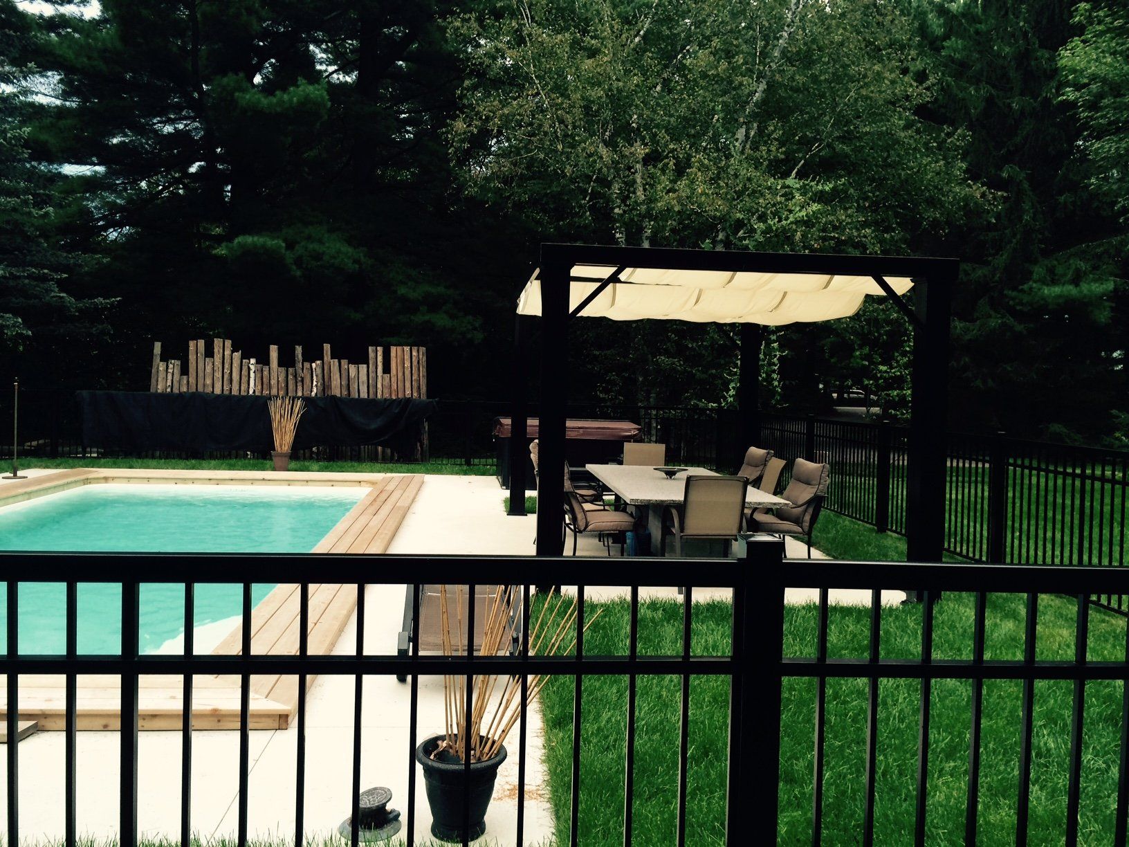 Une clôture noire entoure une grande piscine