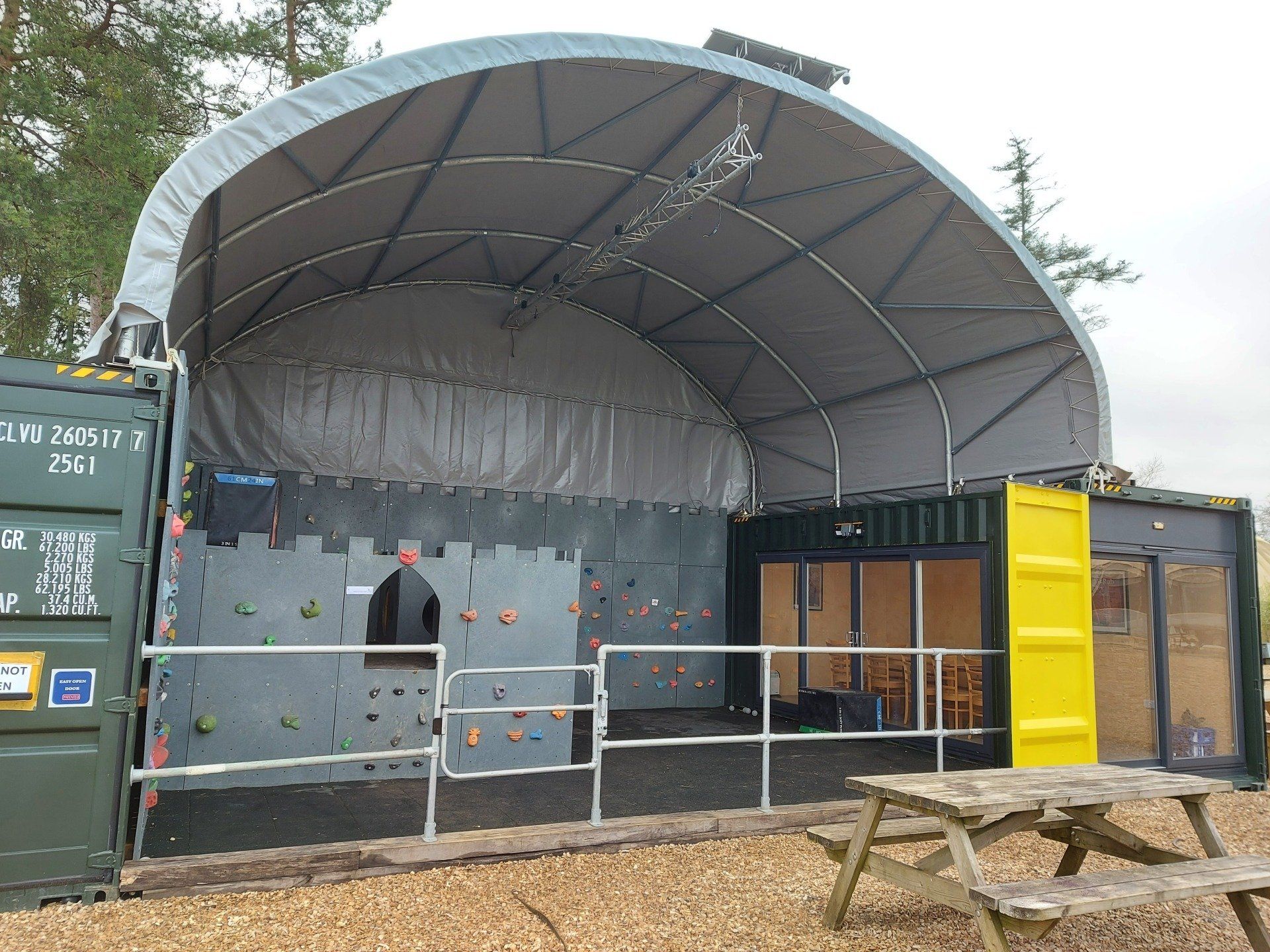 A large tent with a picnic table in front of it