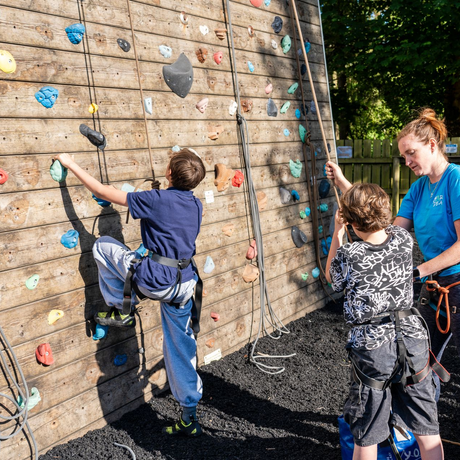 A group of people are standing in front of a climbing wall