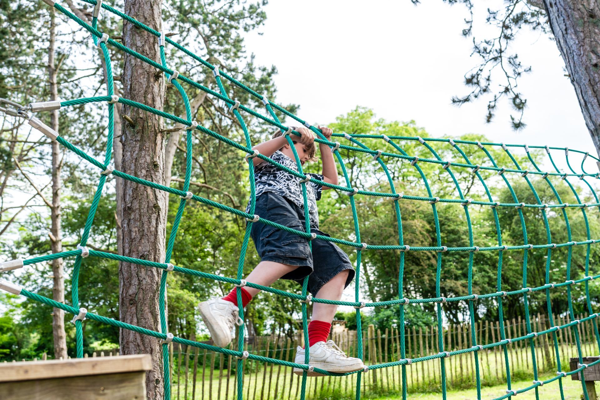 A man in a white shirt is climbing a climbing wall