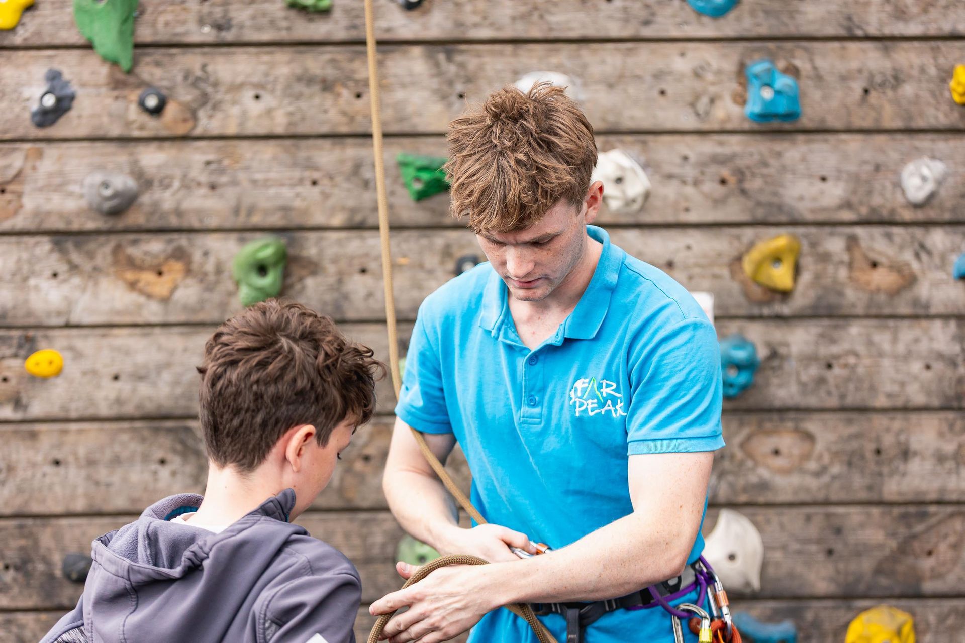 A group of people are climbing a climbing wall.