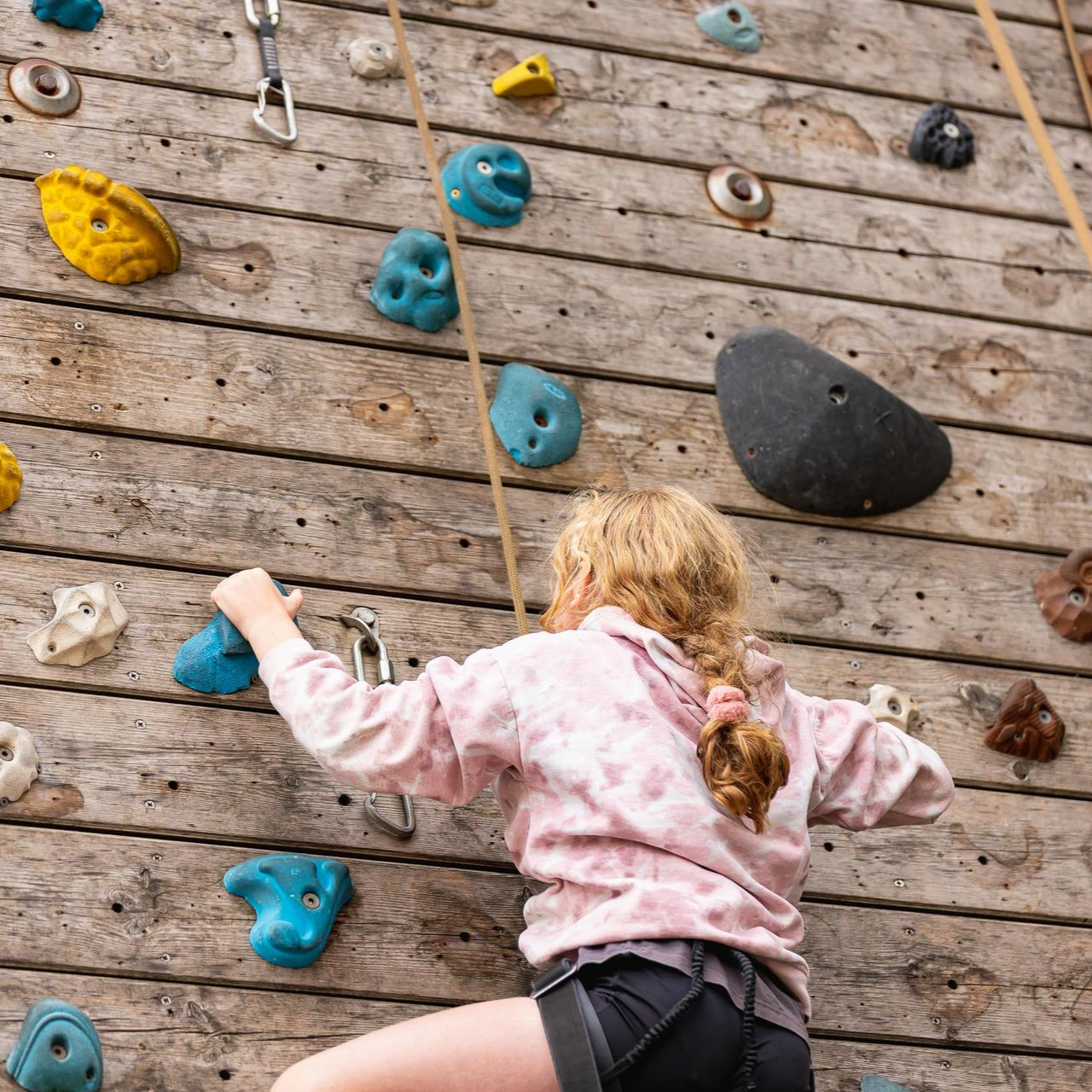 A group of people are climbing a climbing wall