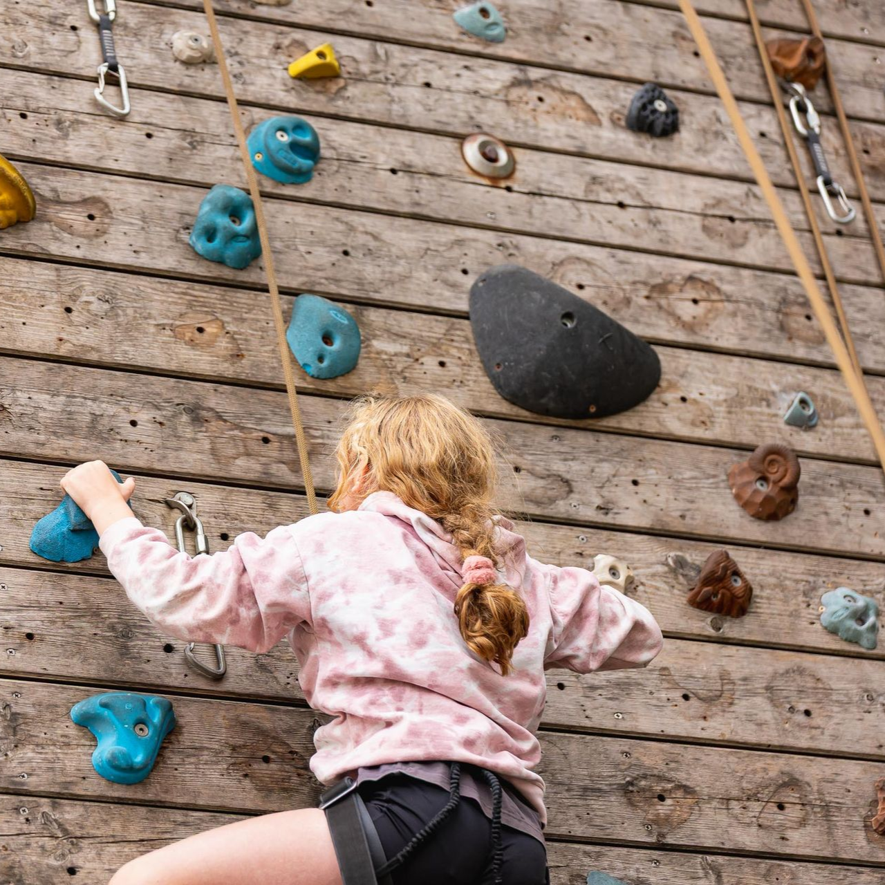 A group of people are climbing a climbing wall