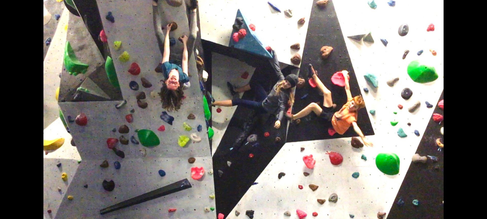 A group of people are climbing a climbing wall.