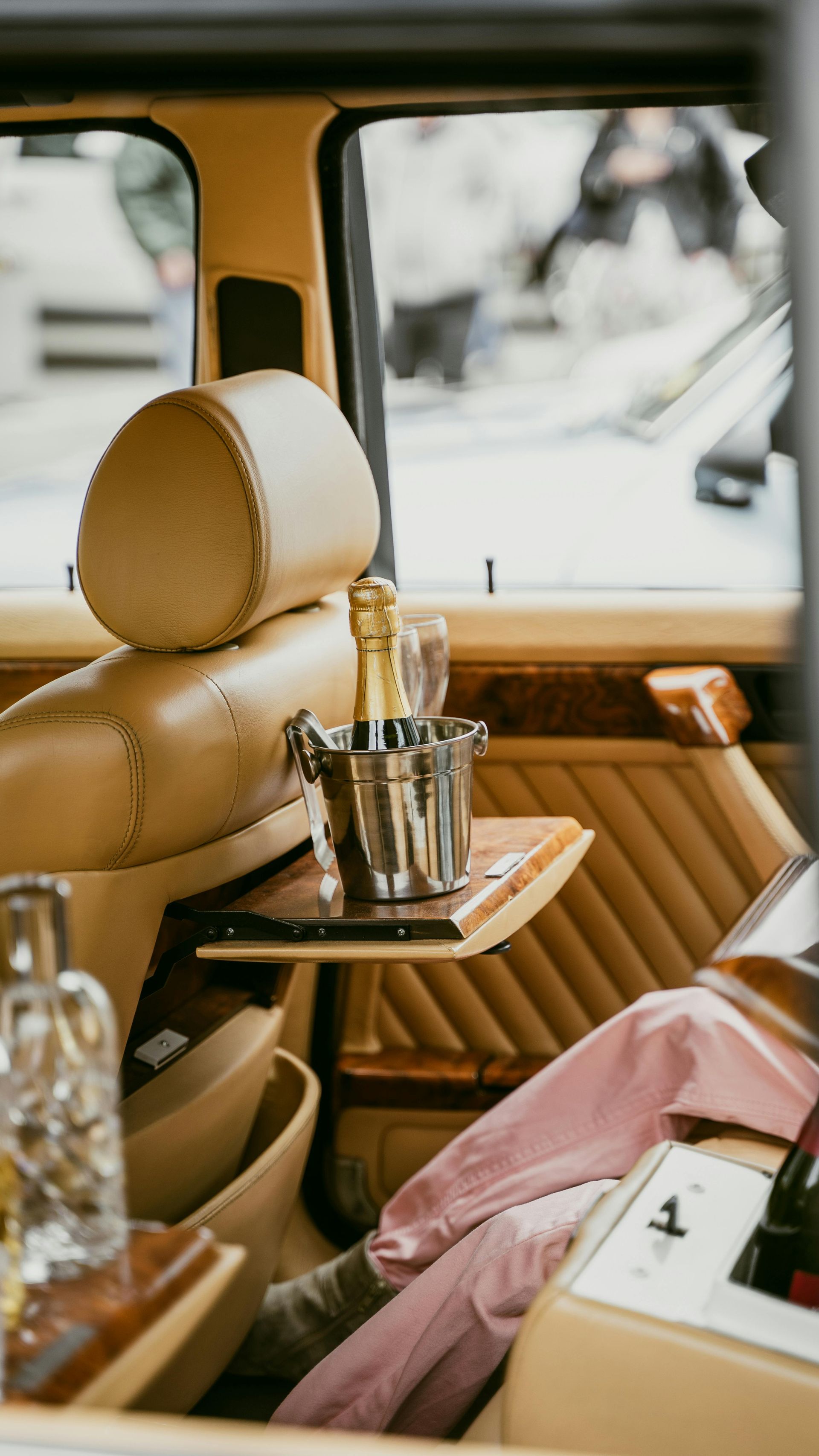 A bottle of champagne is sitting on a table in the back seat of a car.
