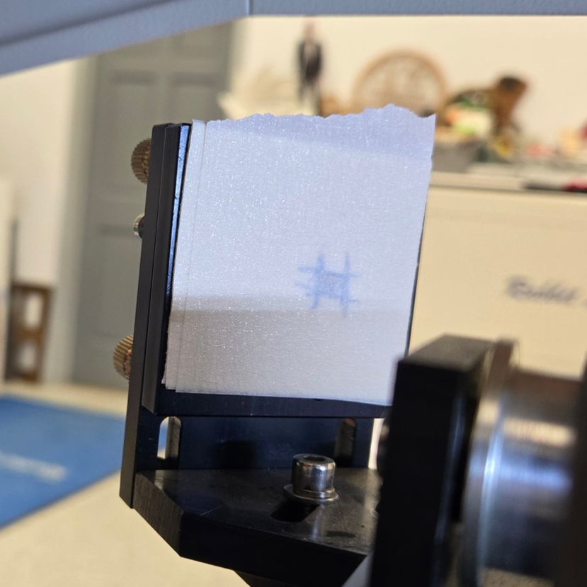 Laser beam test burn mark on masking tape target during flying optics alignment procedure