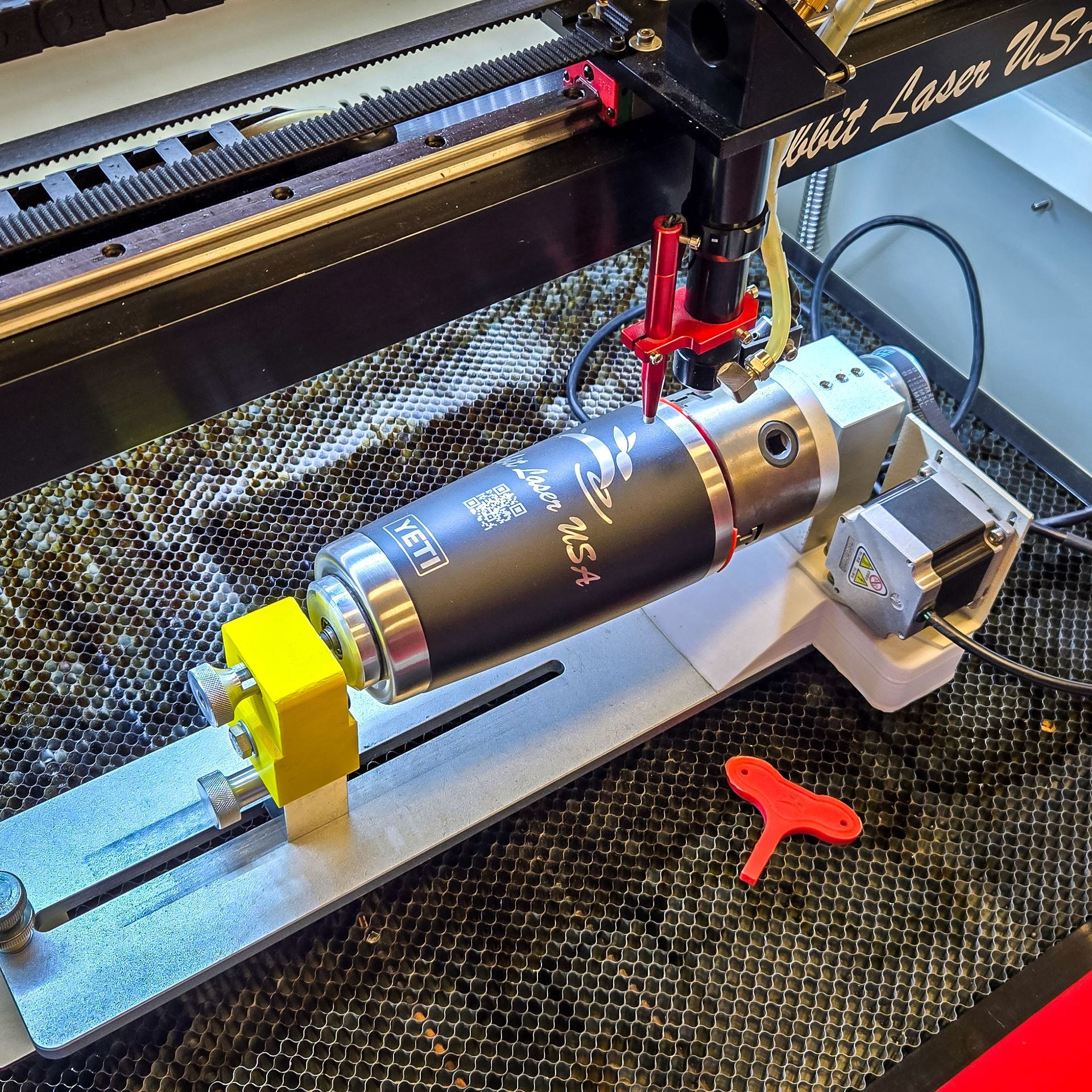 YETI tumbler secured in a chuck rotary inside a Rabbit Laser USA CO2 laser, ready for engraving.
