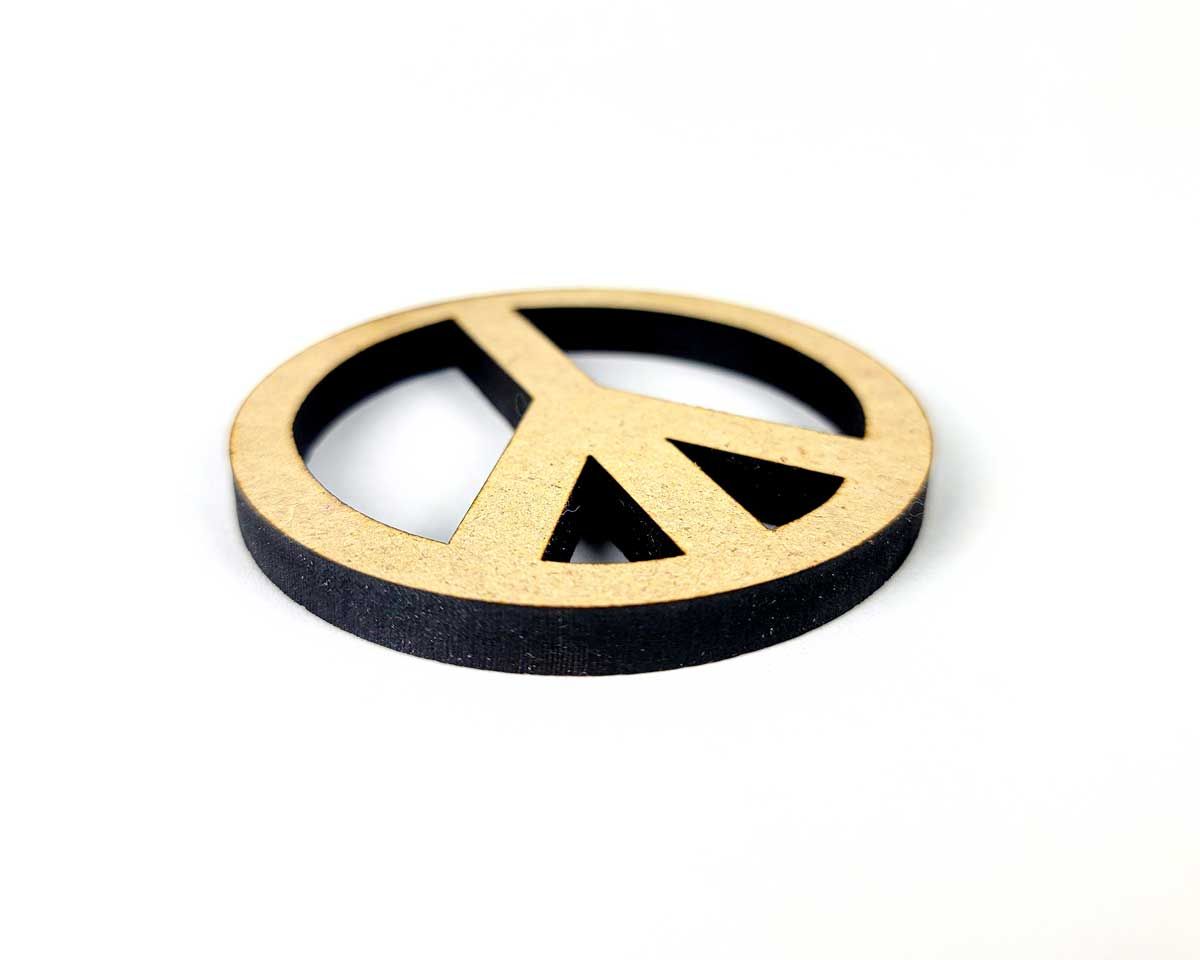 Laser cut peace symbol displayed on white background

