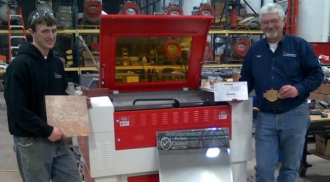 two men posing by their rabbit laser usa machine