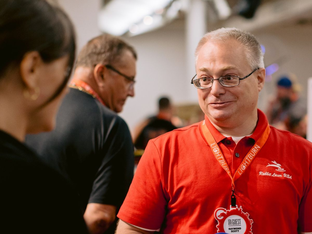 Rabbit Laser USA representative speaking with attendees at a trade show.
