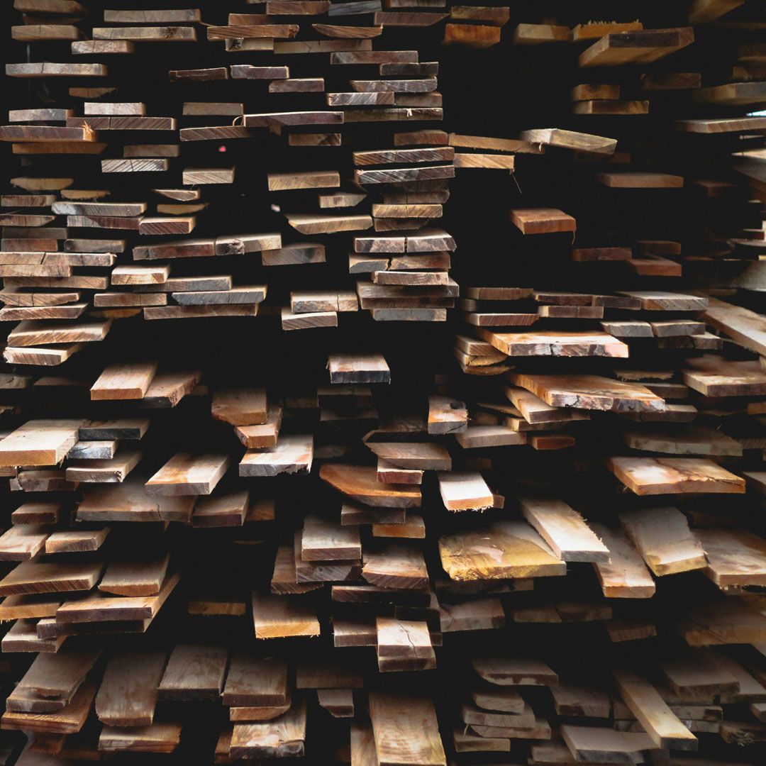Stack of reclaimed wood boards showing varied sizes, grain patterns, and natural character