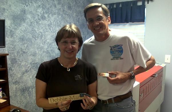happy customer posing with finished projects from their rabbit laser usa machine
