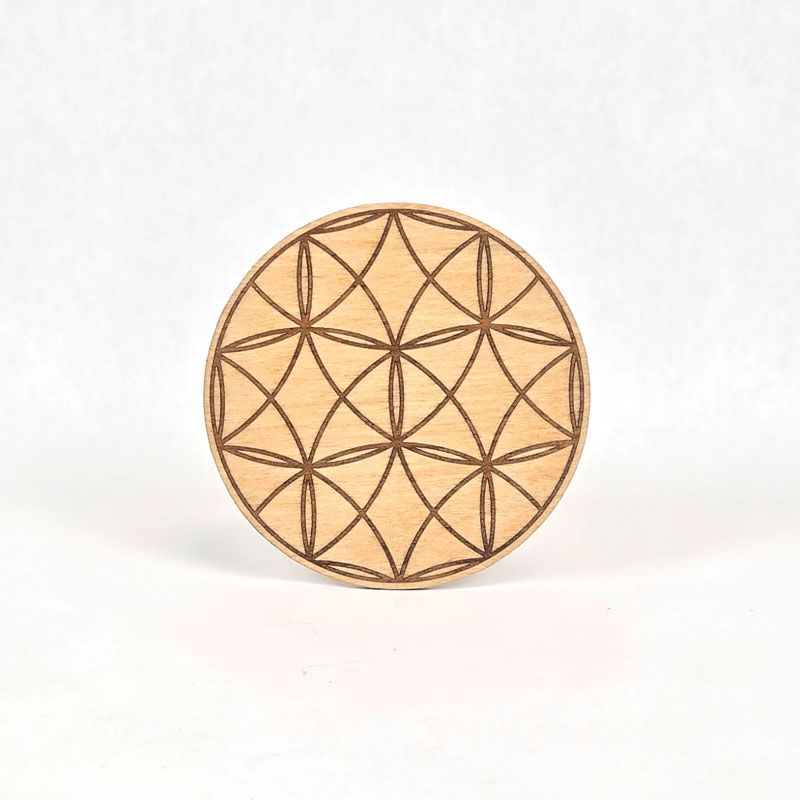 Wood circle engraved with a geometric inlay pattern.