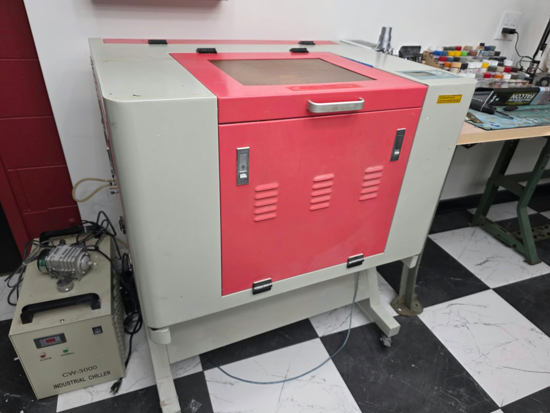 Used RL-80-1290 CO2 laser with red and white cabinet, viewing window, and control panel