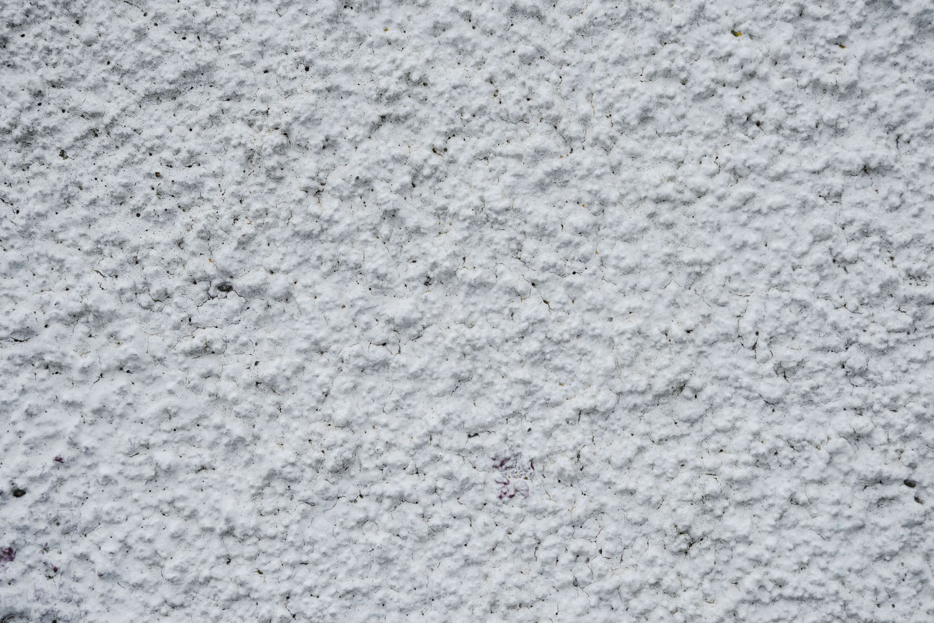 Close-up of a light gray textured stucco wall surface