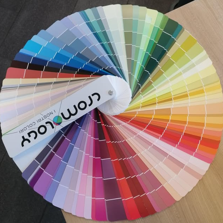Tabella colori a forma di ventaglio con numerose tonalità di pittura, dai blu e verdi ai rosa, rossi e grigi.