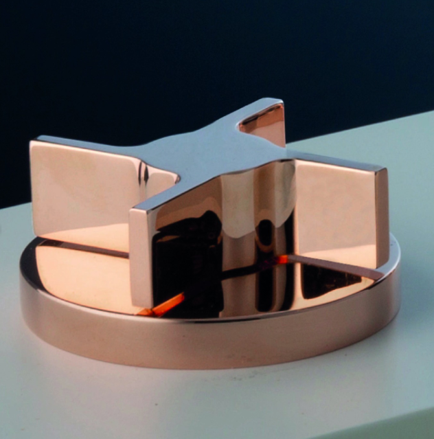 Scultura astratta metallica su base rotonda, con forme geometriche a specchio in argento e rame.