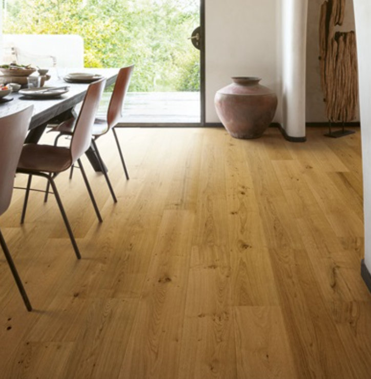 Sala da pranzo moderna con pavimento in legno chiaro, tavolo e sedie e ampia finestra.