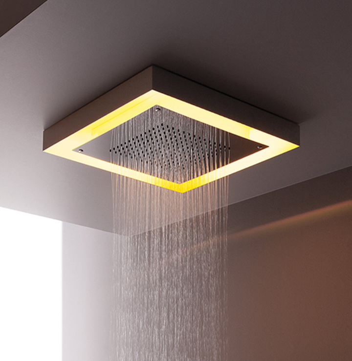 Doccia a pioggia quadrata con soffitto illuminato da una luce calda che spruzza acqua verso il basso.