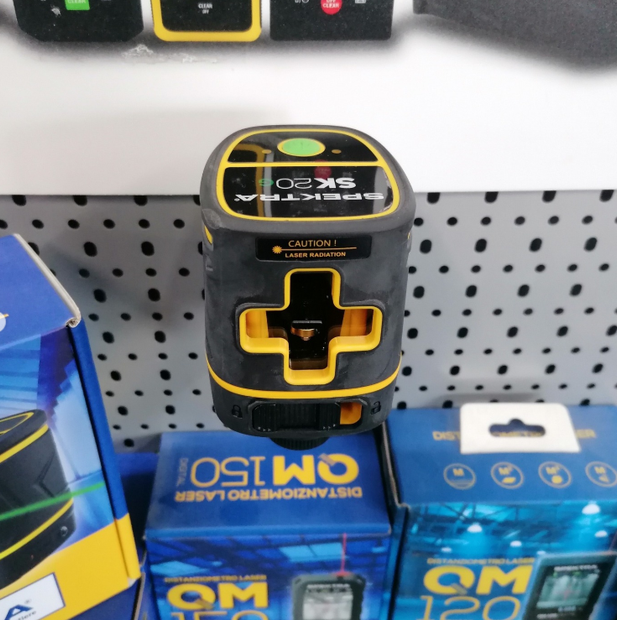Dispositivo portatile nero e giallo su una pila di scatole di prodotti blu in un espositore di un negozio.