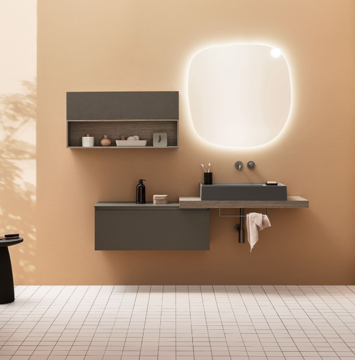 Bagno moderno con pareti beige, mobile lavabo sospeso grigio, specchio illuminato e pavimento piastrellato.