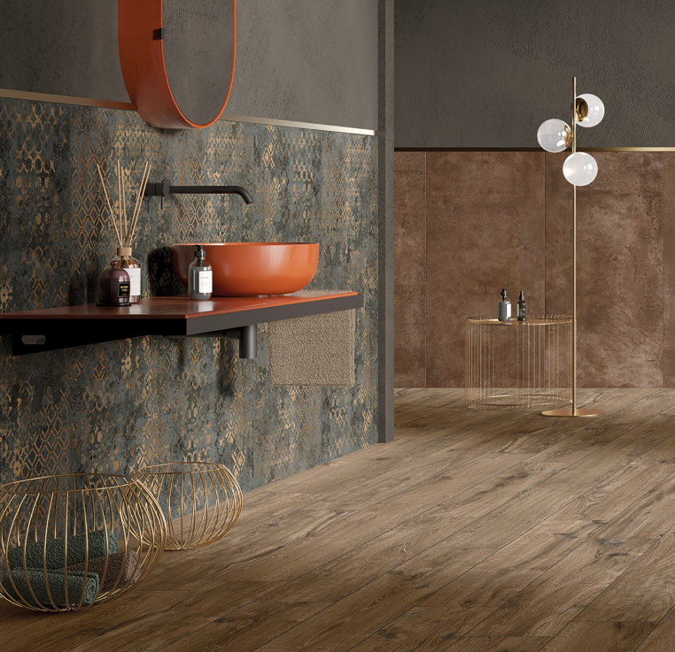 Bagno moderno con pareti marroni texturizzate, lavabo arancione, mensola sospesa e pavimento effetto legno.
