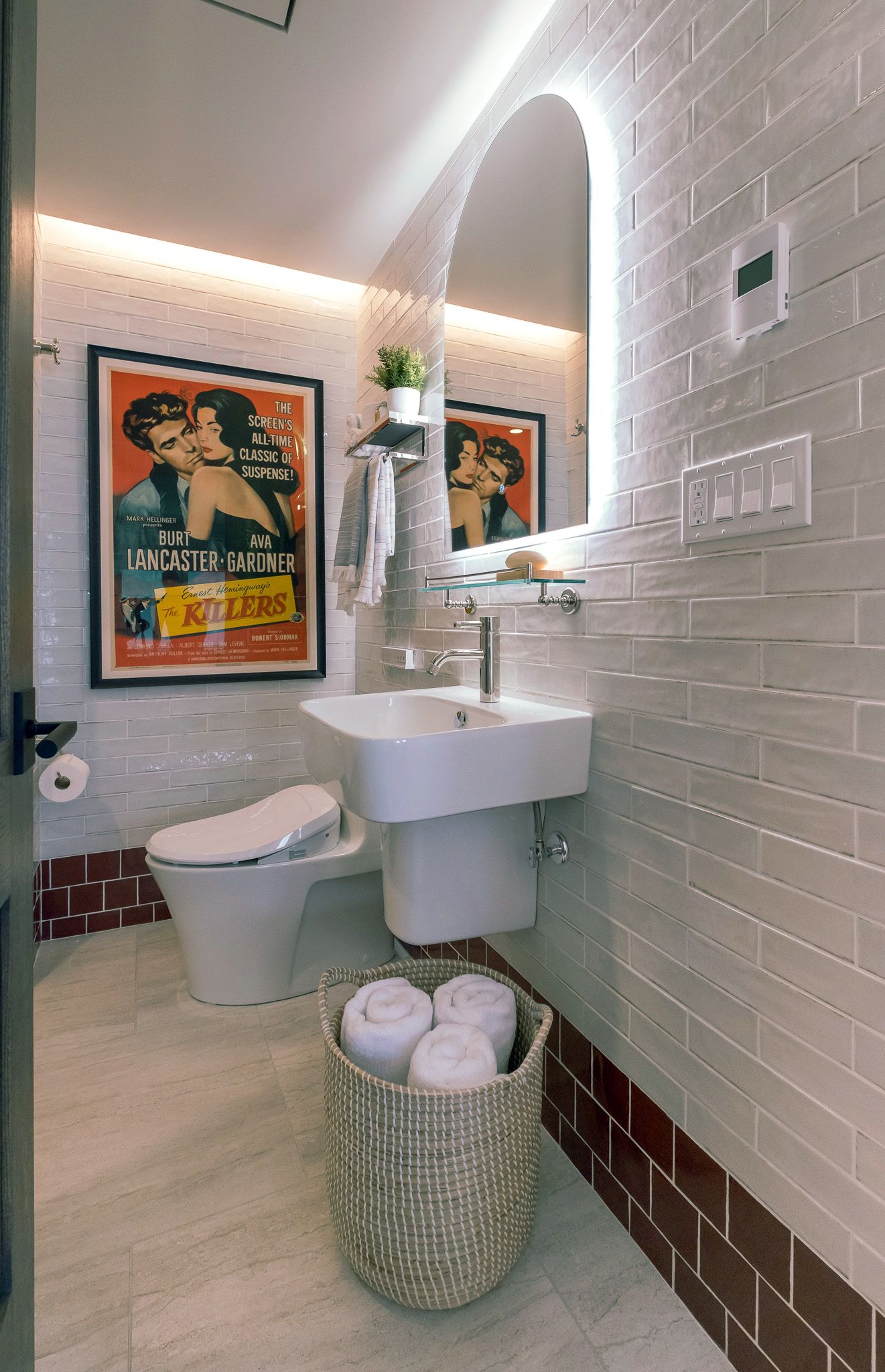 A bathroom with a sink, toilet, and mirror.