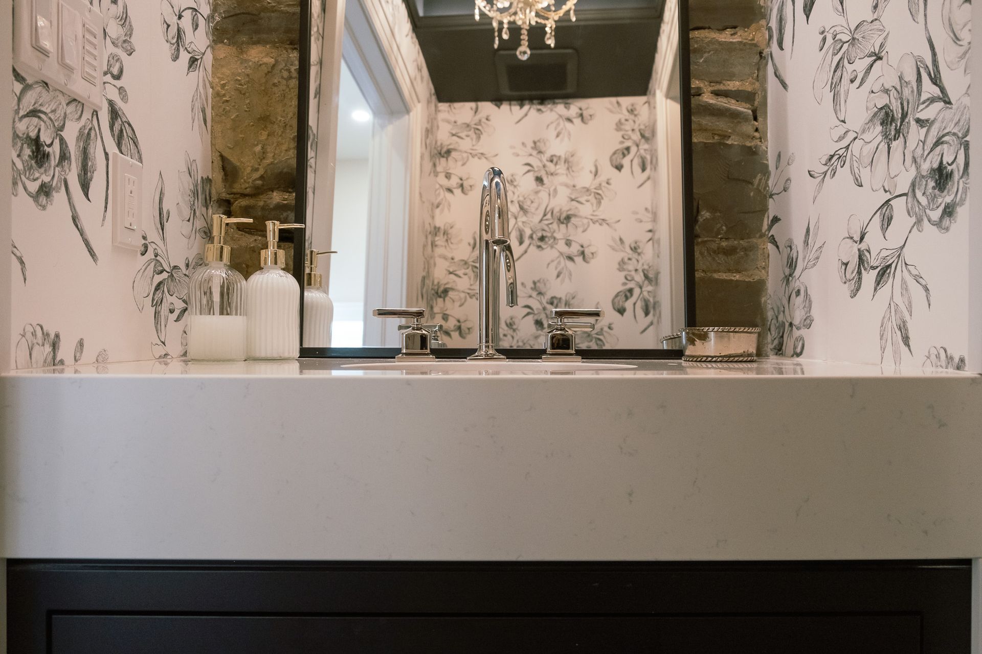 A bathroom with a sink with a mirror in the background.